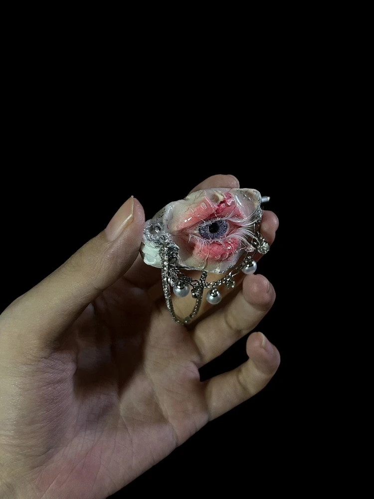 TQART handcrafted realistic purple eyeball set in a seashell, showing the brooch pin back.